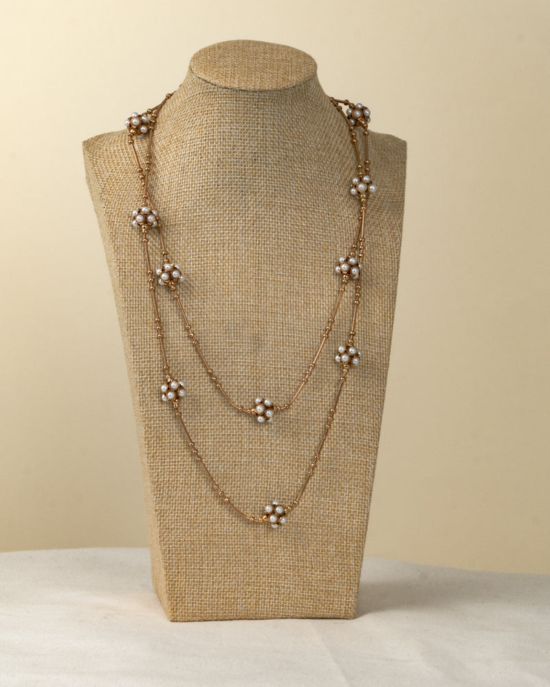 Collar largo de metal dorado con flores de perlas
