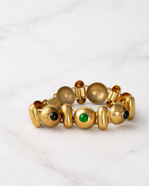 Brazalete de eslabones de metal dorado con cabujones de piedras verdes y negras