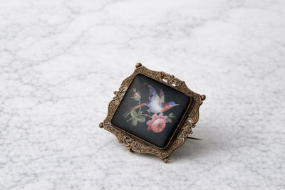 Broche de metal dorado victoriano con dibujo de ave y flor